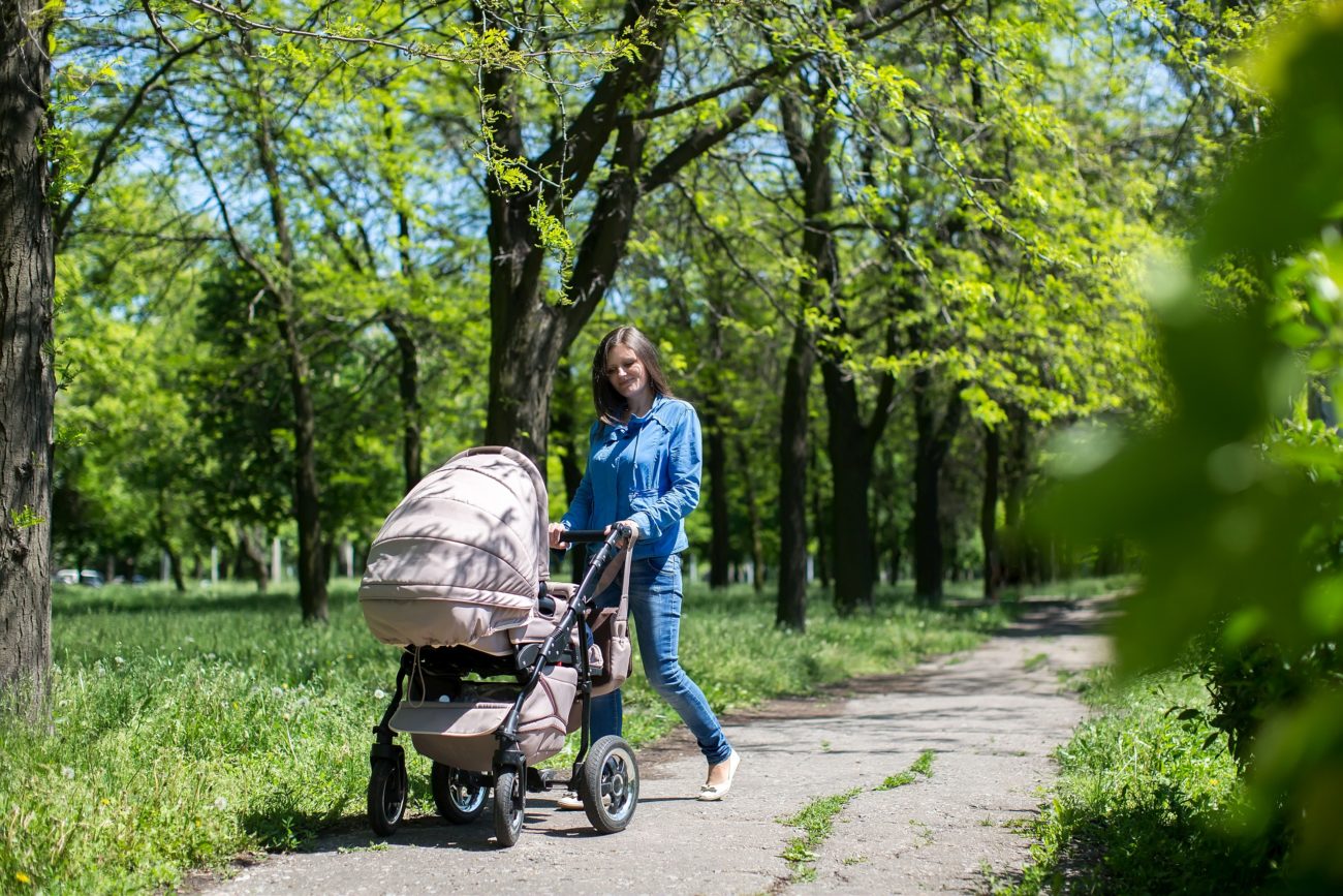 mama s dieťaťom v kočíku v parku