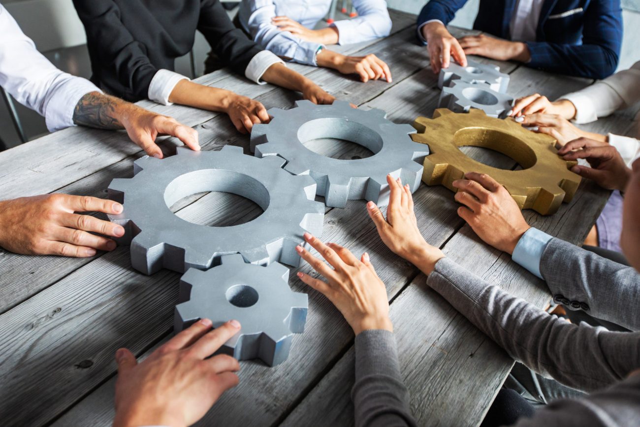 Business people joining gears Dohodári