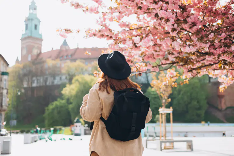 turistka pod rozkvinutným stromom uprostred mesta