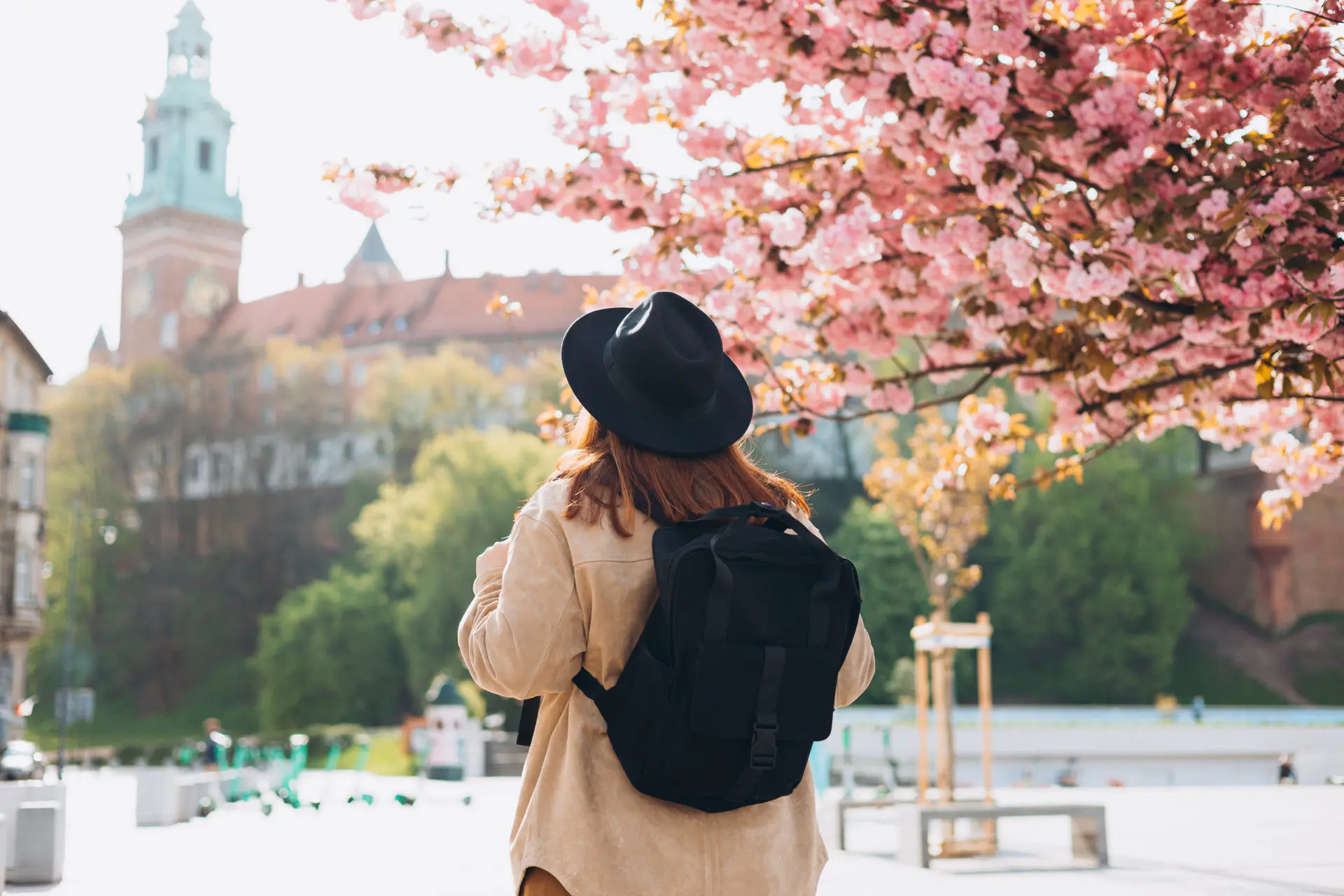 turistka pod rozkvinutným stromom uprostred mesta