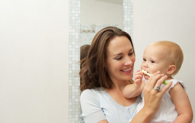 umývanie prvých zúbkov, mama umýva bábätku zuby