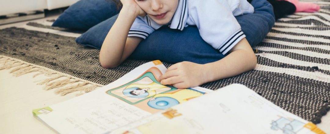 Zistite či má dieťa dyslexiu, test dyslexie, chlapec na podlahe číta knihu