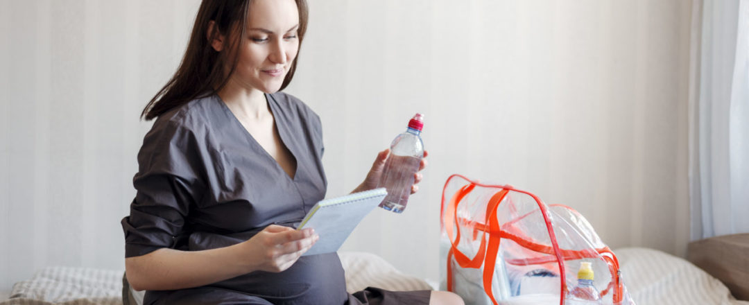 tehotná žena baliaca veci do pôrodnice