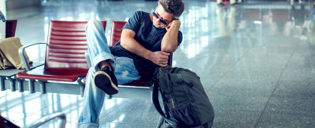 muž čakajúci na odlet na letisku