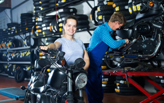 žena s motorkou v servise