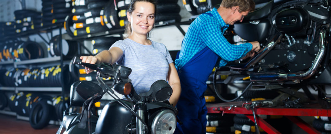 žena s motorkou v servise