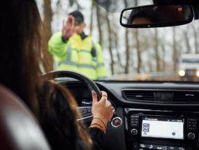 Policajná hliadka zastavuje vodičku auta