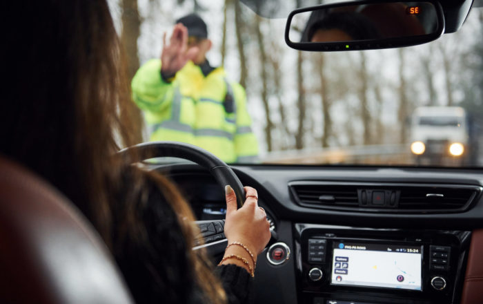 Policajná hliadka zastavuje vodičku auta