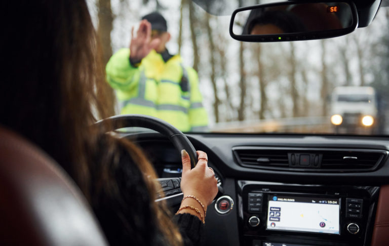 Policajná hliadka zastavuje vodičku auta