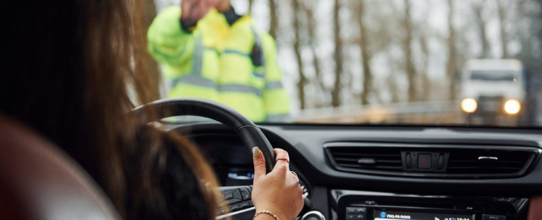 Policajná hliadka zastavuje vodičku auta