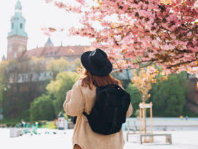 turistka pod rozkvinutným stromom uprostred mesta