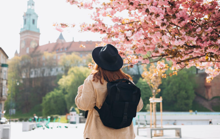 turistka pod rozkvinutným stromom uprostred mesta