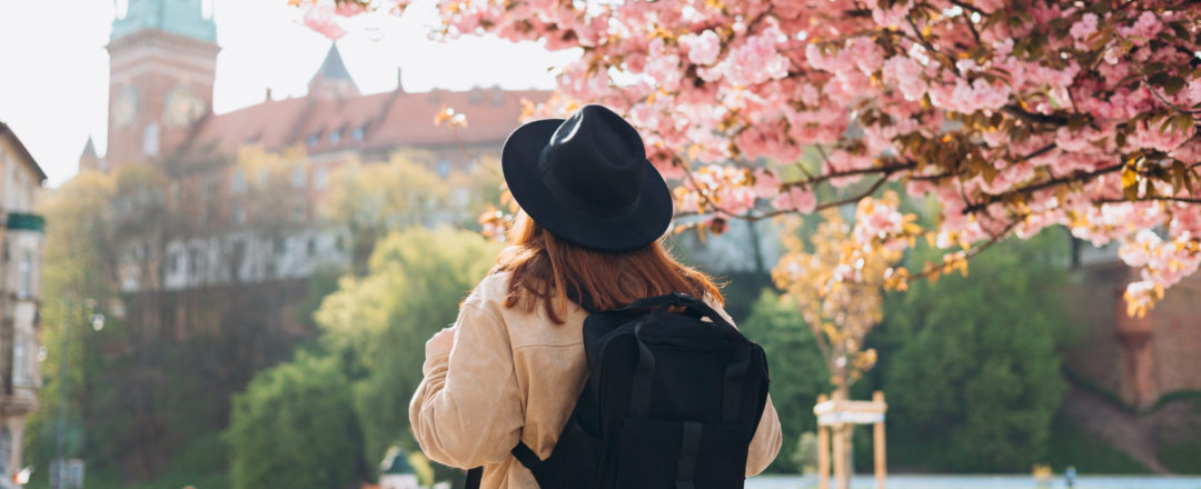 turistka pod rozkvinutným stromom uprostred mesta