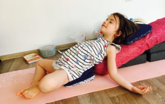 dievčatko ležiace na vankúšoch v relaxačnej polohe